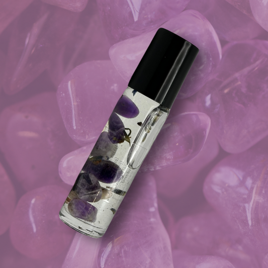 Amethyst Crystal Perfume Roller, clear bottle black top, amethyst stone background top view 